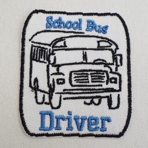 Könnte beinhalten: Gestickter Aufnäher mit einem schwarz-weißen Schulbus-Design, den Worten "School Bus" oben und "Driver" unten in Blau. Der Aufnäher hat einen weißen Hintergrund und einen schwarzen Rand.