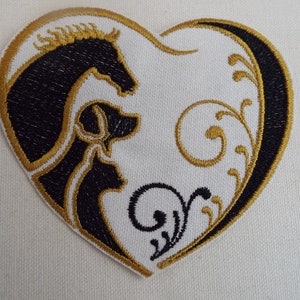 May include: Embroidered heart-shaped patch with a black silhouette of a horse and dog, outlined in gold thread. The background is white with gold floral designs.