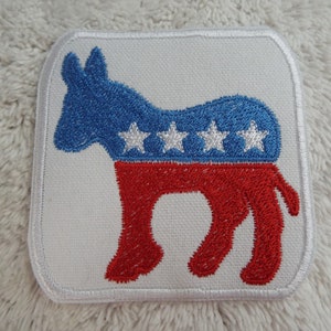May include: A white fabric patch with a red and blue embroidered donkey silhouette. The donkey has five white stars on its back.
