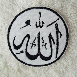 Op de afbeelding: Een ronde, witte patch met zwart geborduurde Arabische kalligrafie. De kalligrafie, "Allah", is omgeven door een zwarte rand. De patch, waarschijnlijk van stof, is bedoeld om op kleding of accessoires te naaien of te strijken.
