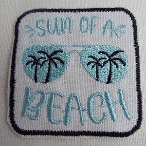 Pode incluir: Etiqueta branca bordada com texto azul que diz "Sun of a Beach" e um par de óculos de sol com palmeiras dentro das lentes.