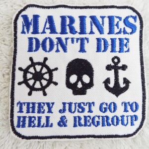May include: White embroidered patch with blue text that reads "Marines Don't Die They Just Go To Hell & Regroup". The patch features a black anchor, skull, and ship's wheel.
