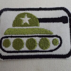 Könnte beinhalten: Grüner gestickter Bügelaufkleber mit einem Cartoon-Panzer mit einem weißen Stern auf dem Turm. Der Panzer hat fünf Räder und einen schwarzen Umriss.