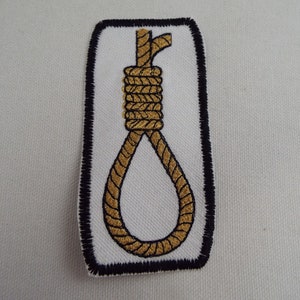 May include: A black and white embroidered patch with a gold rope noose.