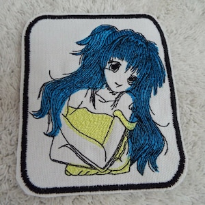 Może przedstawiać: Naszywka haftowana do prasowania przedstawiająca animowaną dziewczynę z długimi niebieskimi włosami, ubraną w żółtą bluzkę. Naszywka ma czarną ramkę.