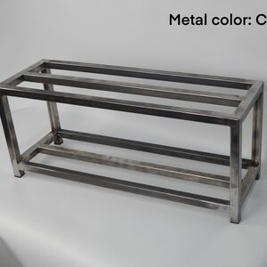 May include: A metal shelf unit with three shelves. The shelf is made of a clear metal and has a rectangular shape.