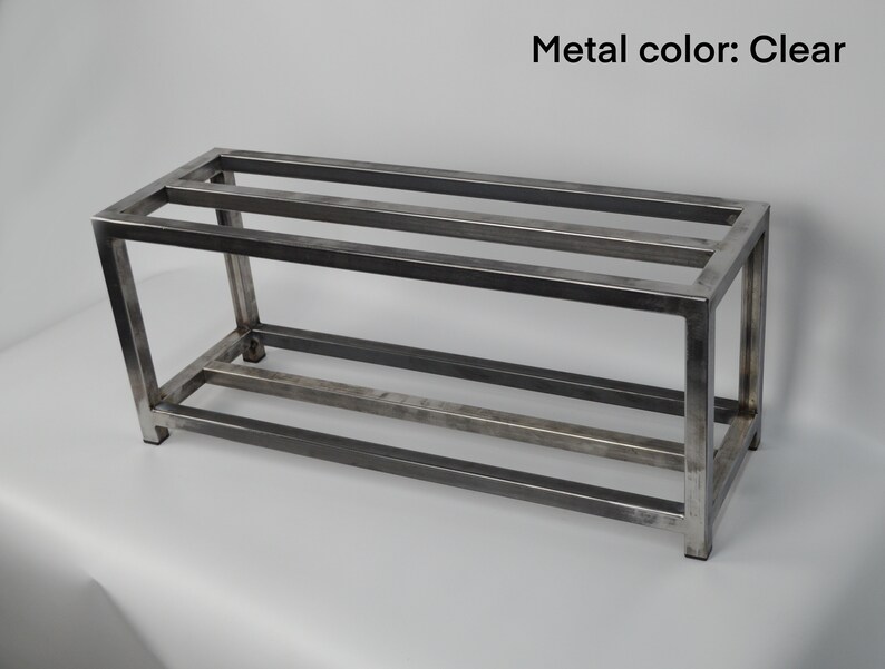 May include: A metal shelf unit with three shelves. The shelf is made of a clear metal and has a rectangular shape.