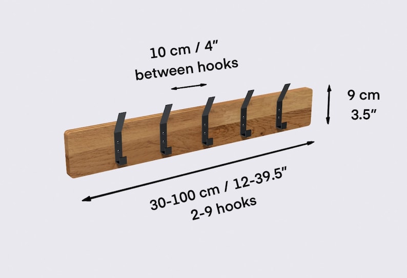 K&ouml;nnte beinhalten: Wandmontierter Kleiderst&auml;nder aus Holz mit 6 schwarzen Metallhaken. Der Kleiderst&auml;nder ist 30-100 cm lang und 9 cm hoch. Die Haken sind 10 cm voneinander entfernt. "10 cm / 4" zwischen den Haken" und "30-100 cm / 12-39.5" 2-9 Haken" sind auf dem Bild zu sehen.