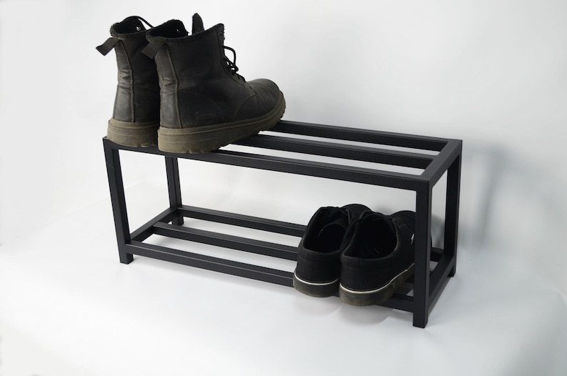 A black metal shoe rack with two tiers.