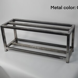 May include: A metal shelf unit with two shelves. The shelf is made of square metal tubing and has a clear finish.