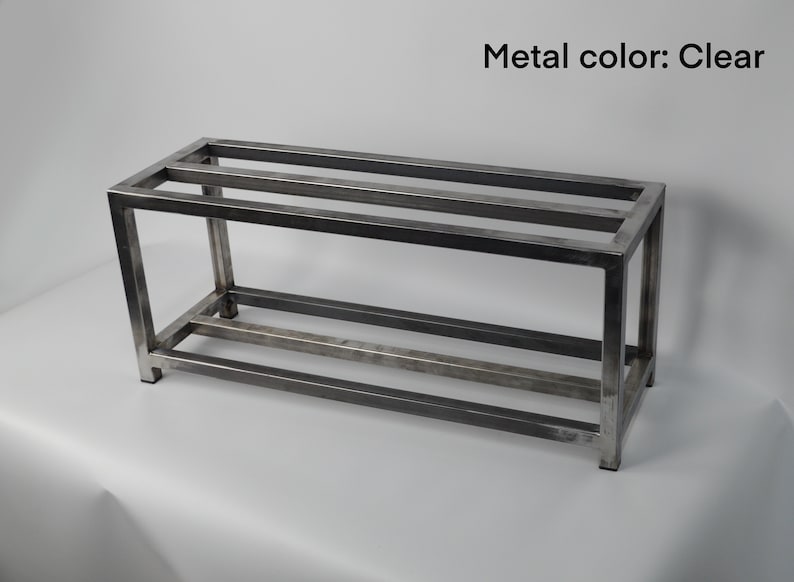 May include: A metal shelf unit with two shelves. The shelf is made of square metal tubing and has a clear finish.