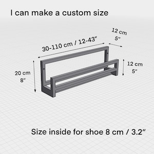 May include: A gray metal shoe rack with two shelves. The rack is 12 inches tall and 30 to 43 inches wide. The inside space for shoes is 8 inches wide. The rack is customizable and can be made in different sizes.