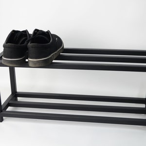 A black metal tier shoe rack.