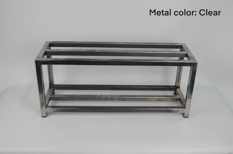 May include: A metal shelf unit with three shelves. The shelf is made of square metal tubing and has a clear metal finish.