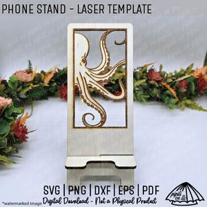 May include: A wooden phone stand laser template with an octopus design. The stand has a rectangular cutout with an octopus illustration. The text "PHONE STAND - LASER TEMPLATE" is at the top. The bottom has the text "SVG | PNG | DXF | EPS | PDF".