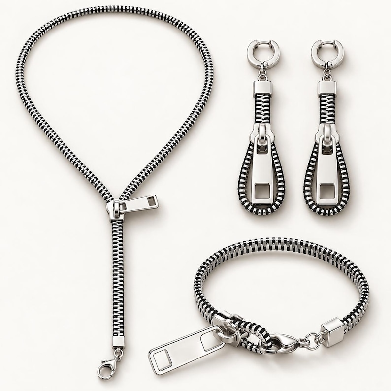 May include: A jewelry set consisting of a necklace, a bracelet, and a pair of drop earrings. Each piece is designed to resemble a black and silver zipper with a metallic pull tab. The necklace and bracelet feature lobster claw clasps.