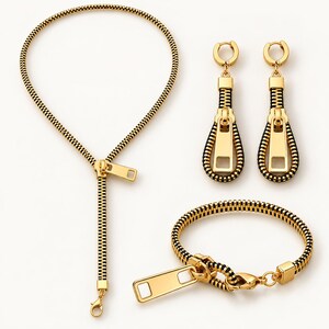 May include: A jewelry set consisting of a necklace, a bracelet, and a pair of drop earrings. Each piece is crafted from a black and gold zipper design, featuring a gold metal zipper pull tab as a central decorative element on each item.