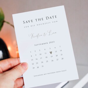 May include: Save the date card with a calendar for September 2023. The date of the wedding is marked with a heart on the 5th. The card reads "Save the Date" and "For the wedding of Kerstin & Liam".