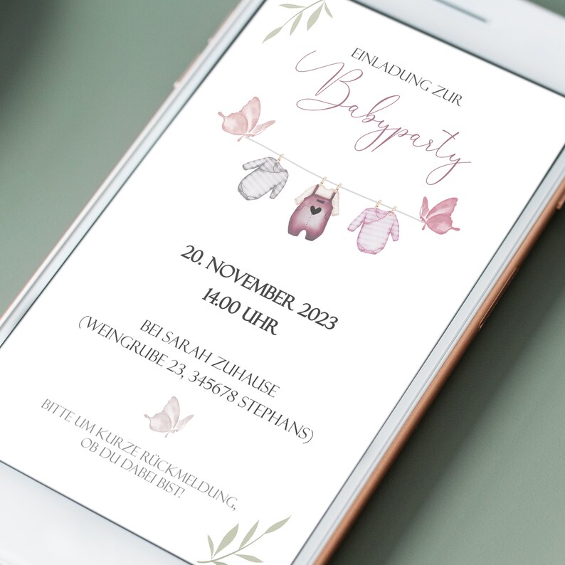 May include: A pink and white baby shower invitation with a clothesline and butterflies. The text reads "Einladung zur Babyparty" and includes the date and time of the event: "20. November 2023, 14.00 Uhr". The invitation also includes the address: "Bei Sarah Zuhause (Weingrube 23, 345678 Stephans)".
