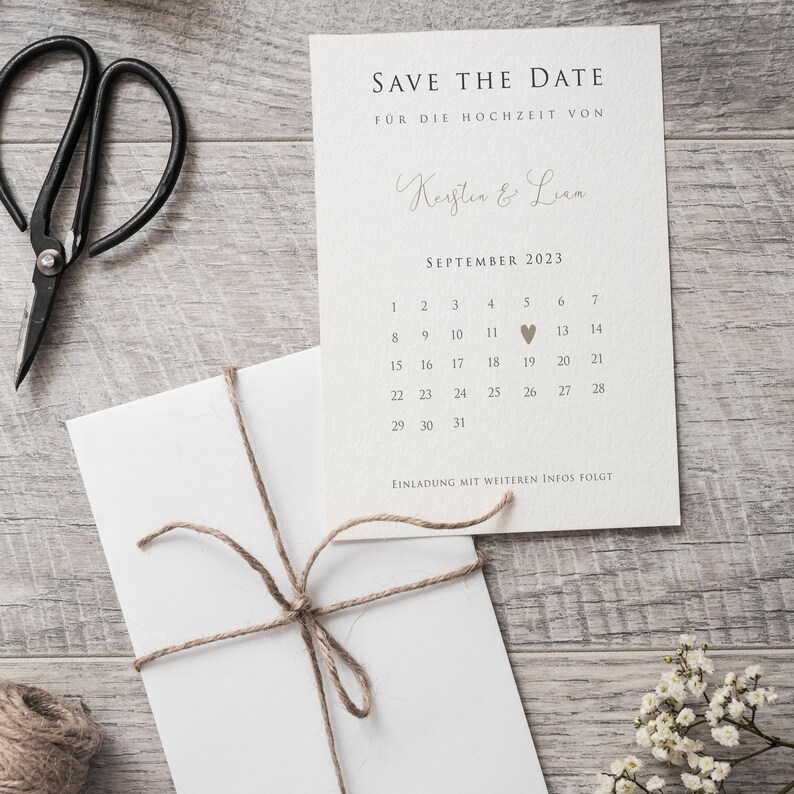 May include: Save the date card with a calendar for September 2023. The date of the 19th is marked with a heart. The card says "Save the Date" and "For the wedding of Kerstin & Lian".