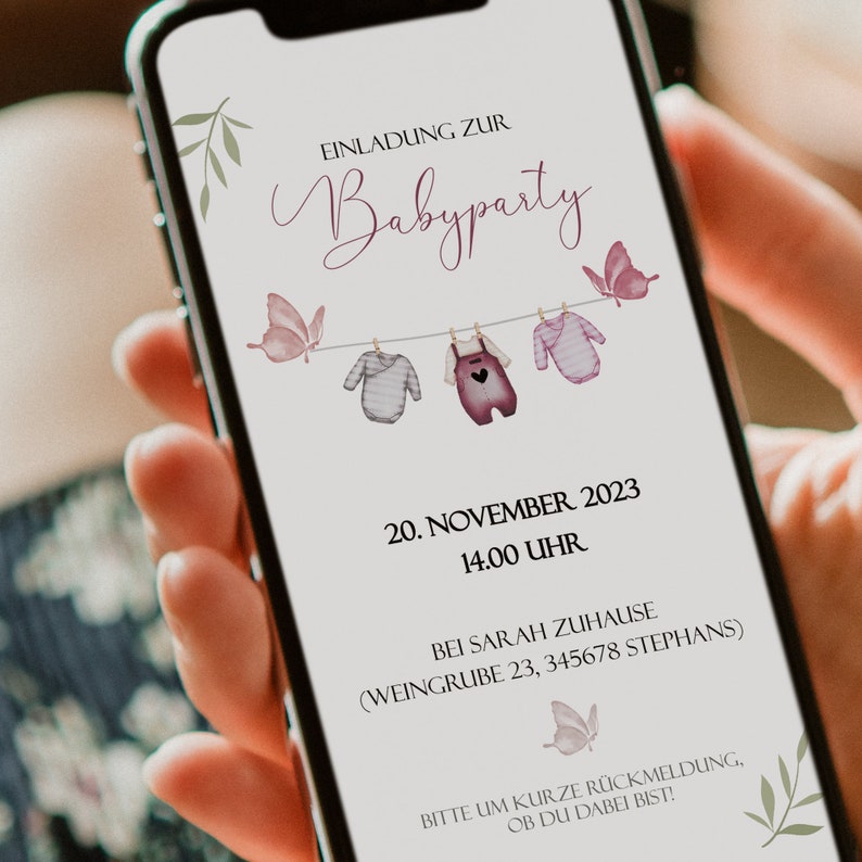 May include: A digital invitation for a baby shower with a pink and gray color scheme. The invitation features a string of clothesline with baby clothes hanging on it and butterflies. The text reads "Einladung zur Babyparty" and includes the date, time, and location of the event.