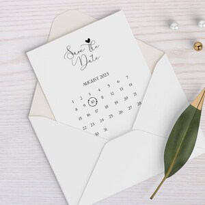 May include: A white card with the text "Save the Date" and a calendar with the date August 10, 2023 circled.