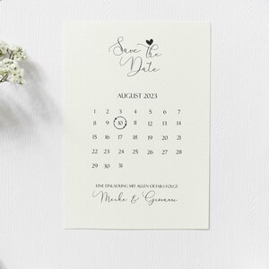 May include: Save the Date card with a calendar featuring August 2023 with the 10th circled. The text "Eine Einladung mit allen Details folgt. Meike & Giovanni" is at the bottom of the card.