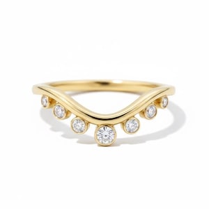 Pode incluir: Um anel dourado com um design curvo, apresentando sete pedras preciosas redondas e transparentes. A banda do anel tem uma forma de onda, com as pedras preciosas espaçadas uniformemente ao longo da curva. O anel está sobre um fundo branco.