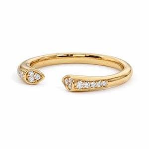 May include: A gold open-style ring featuring a polished band with two tapered ends. Each end is set with a cluster of small, round, clear white diamonds, with three stones on one side and a row of six stones on the other side of the band.