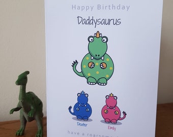 May include: A birthday card with a green dinosaur with yellow spots and the text "Happy Birthday Daddysaurus have a roarsome day". There are two smaller dinosaurs, one blue and one pink, with the names "Dexter" and "Emily" below them.