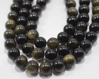 May include: A strand of black and gold beads. The beads are round and have a smooth, polished finish. The gold flecks in the beads are visible.