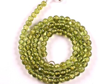 May include: A green gemstone necklace with round beads and a silver clasp.