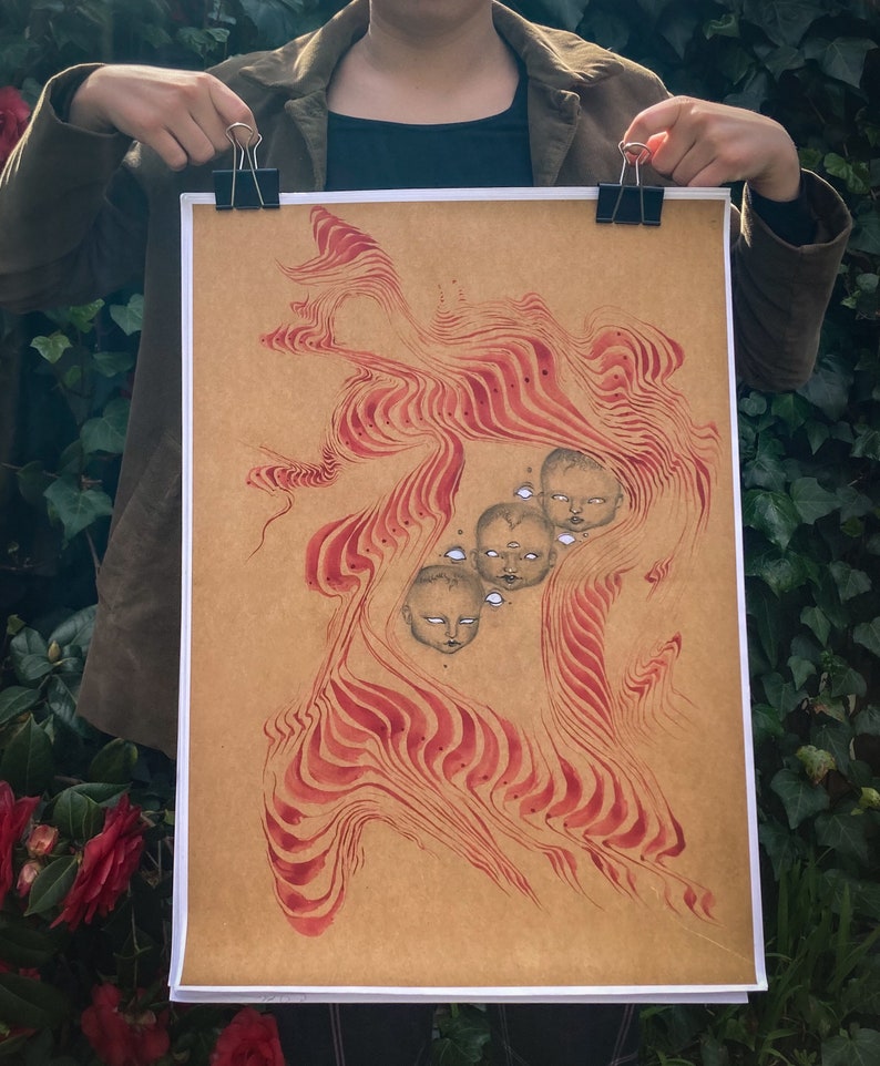 May include: A brown paper print with a red and white abstract design. The design features multiple stylized faces with closed eyes.