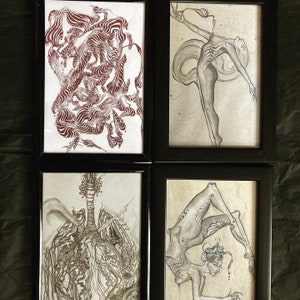 May include: Four framed black and white ink drawings. The top left drawing features a swirling pattern of lines. The top right drawing features a figure with long limbs and a long tail. The bottom left drawing features a swirling pattern of lines. The bottom right drawing features a figure with long limbs and a long tail.