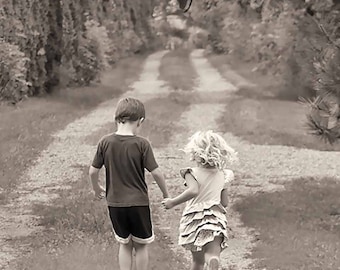 Op de afbeelding: Een zwart-witfoto van twee kinderen die over een pad in een bos lopen. De kinderen houden elkaars hand vast, de jongen draagt een T-shirt en een korte broek, en het meisje draagt een jurk. De bijschrift luidt "Moge jullie handen voor altijd in vriendschap verbonden zijn."