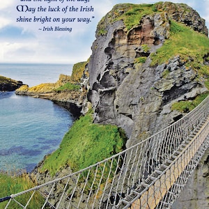 May include: A rope bridge spans a narrow gap between two rocky cliffs overlooking a body of water. The sky is blue with white clouds. The text "Like the warmth of the sun, and the light of the day, May the luck of the Irish shine bright on your way." ~ Irish Blessing is written on the cliff face.