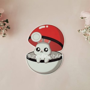 May include: A white bunny with pink ears and big eyes is inside a red and white Pokeball. The Pokeball is open and the bunny is looking out. The text "BunnyBrushArt" is written below the Pokeball.