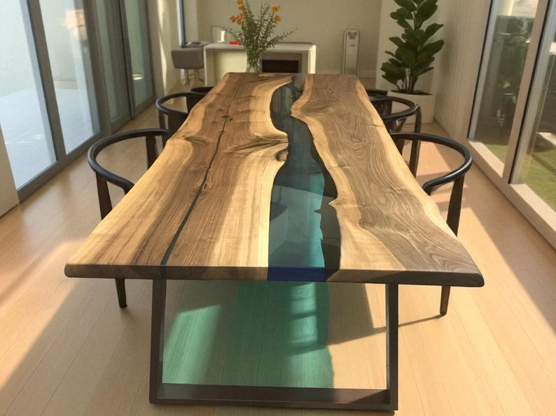 Puede incluir: Una mesa de comedor rectangular con un tablero de madera de borde natural y una incrustaci&oacute;n central de resina turquesa transl&uacute;cida. La mesa se apoya sobre una base de metal oscuro y est&aacute; rodeada por cuatro sillas negras curvas.