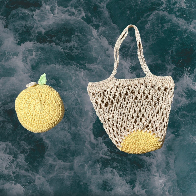May include: A crocheted lemon-shaped bag with a white crocheted handle and a yellow crocheted lemon design. The bag is on a blue and white textured background.