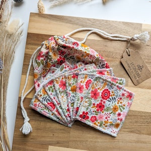 May include: A set of 10 reusable cotton rounds in a floral print with a drawstring bag. The bag is made of cotton and has a floral print. The rounds are made of cotton and are soft and absorbent. The bag is labelled "ECONABEE Handmade Reusable Eco Products".