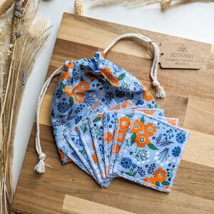 May include: A set of reusable cotton rounds in a blue floral print with orange flowers. The rounds are in a drawstring bag with a tag that reads "ECONABEE HANDMADE REUSABLE ECO PRODUCTS".