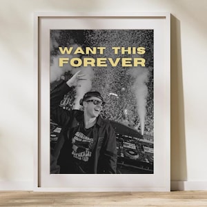 May include: Black and white photo of a man in a hat and sunglasses performing on stage. The text "WANT THIS FOREVER" is written in yellow above him.