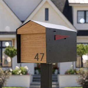 Peut inclure: Une bo&icirc;te aux lettres avec un ext&eacute;rieur en m&eacute;tal noir et un panneau avant en bois clair. Le num&eacute;ro 47 est affich&eacute; en noir sur la face en bois. Un petit drapeau en m&eacute;tal rouge est fix&eacute; sur le c&ocirc;t&eacute; du bo&icirc;tier noir, mont&eacute; sur un poteau noir.