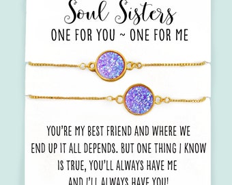 Puede incluir: Dos pulseras de cadena dorada con dijes de purpurina morada. La tarjeta dice "Soul Sisters, One for you ~ One for me. You're my best friend and where we end up it all depends. But one thing I know is true, you'll always have me and I'll always have you!"  glitter & GUMDROPS
