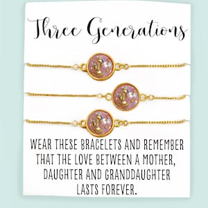 May include: Three gold chain bracelets with pink and gold round charms. The card reads "Three Generations Wear these bracelets and remember that the love between a mother, daughter and granddaughter lasts forever. glitter & GUMDROPS"