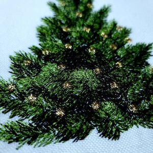 May include: Embroidered Christmas tree design with green foliage and gold accents. The tree is stitched on a white fabric background.
