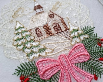 Puede incluir: Diseño navideño bordado con una iglesia blanca con una puerta marrón y un lazo rosa con ramas de pino verdes y bayas rojas.