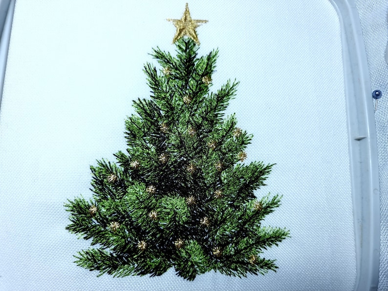 May include: Embroidered Christmas tree with a gold star on top and gold ornaments. The tree is green and the background is white.