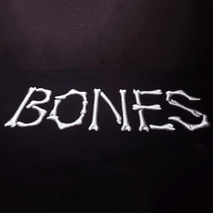 May include: White embroidered text that reads "BONES" on a black background.