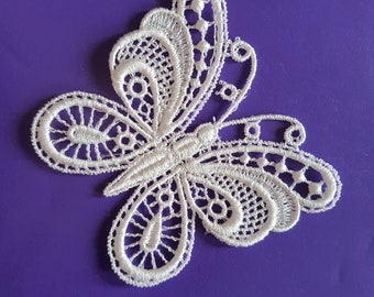 May include: White lace butterfly applique with intricate details. This delicate embellishment is perfect for adding a touch of elegance to crafts, clothing, or home decor.